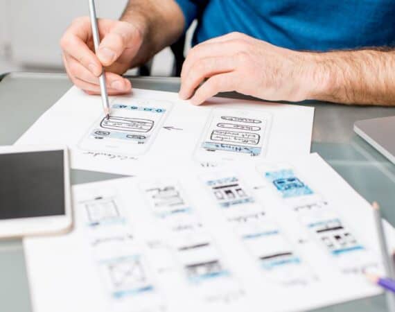 A person sketching out wireframes to design user experience