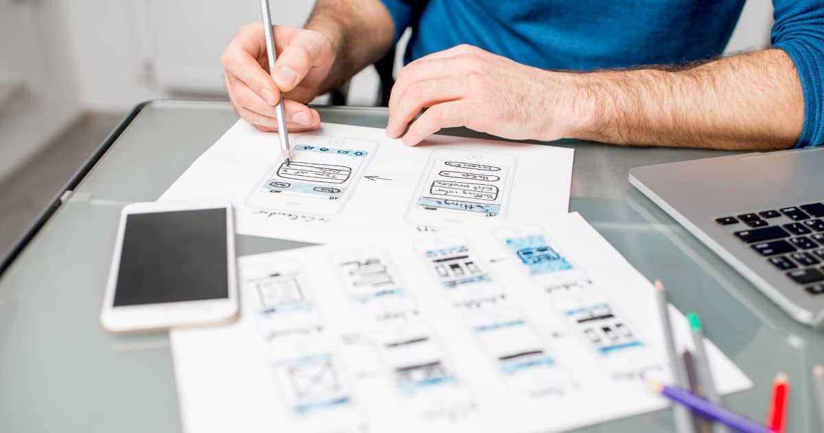 A person sketching out wireframes to design user experience