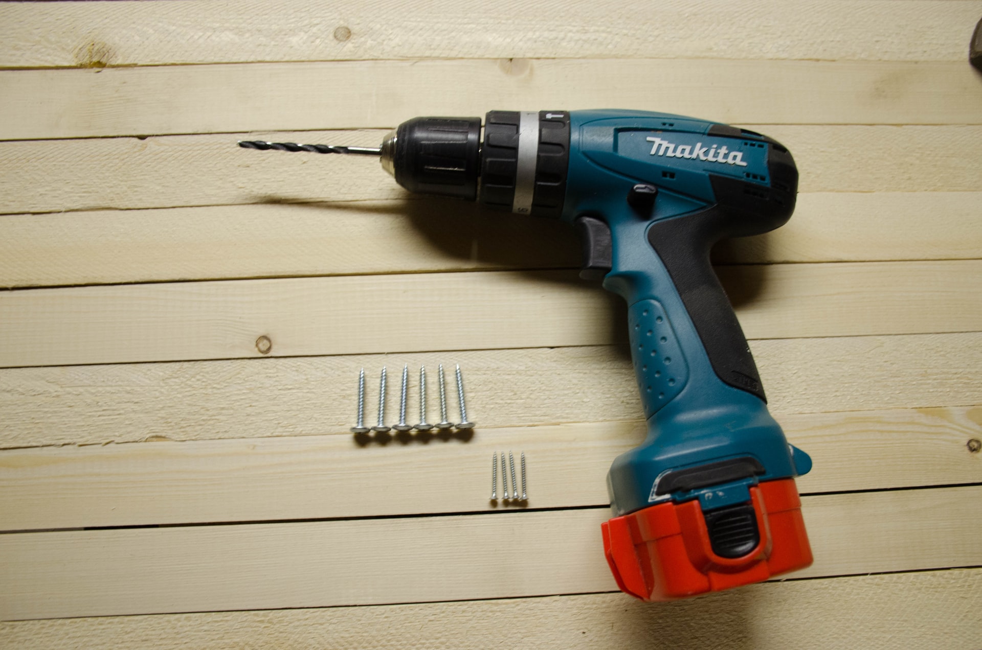 Drill and drill bits on wood background