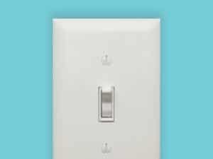 A white light switch against a blue background.