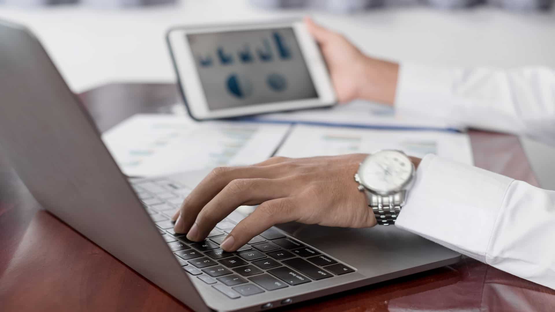 The businessman hand sits at their desks and calculates financial graphs showing the results of their investments planning the process of successful business growth.