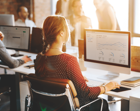 Office workers sitting at desks, analyzing reports that represent data bias.