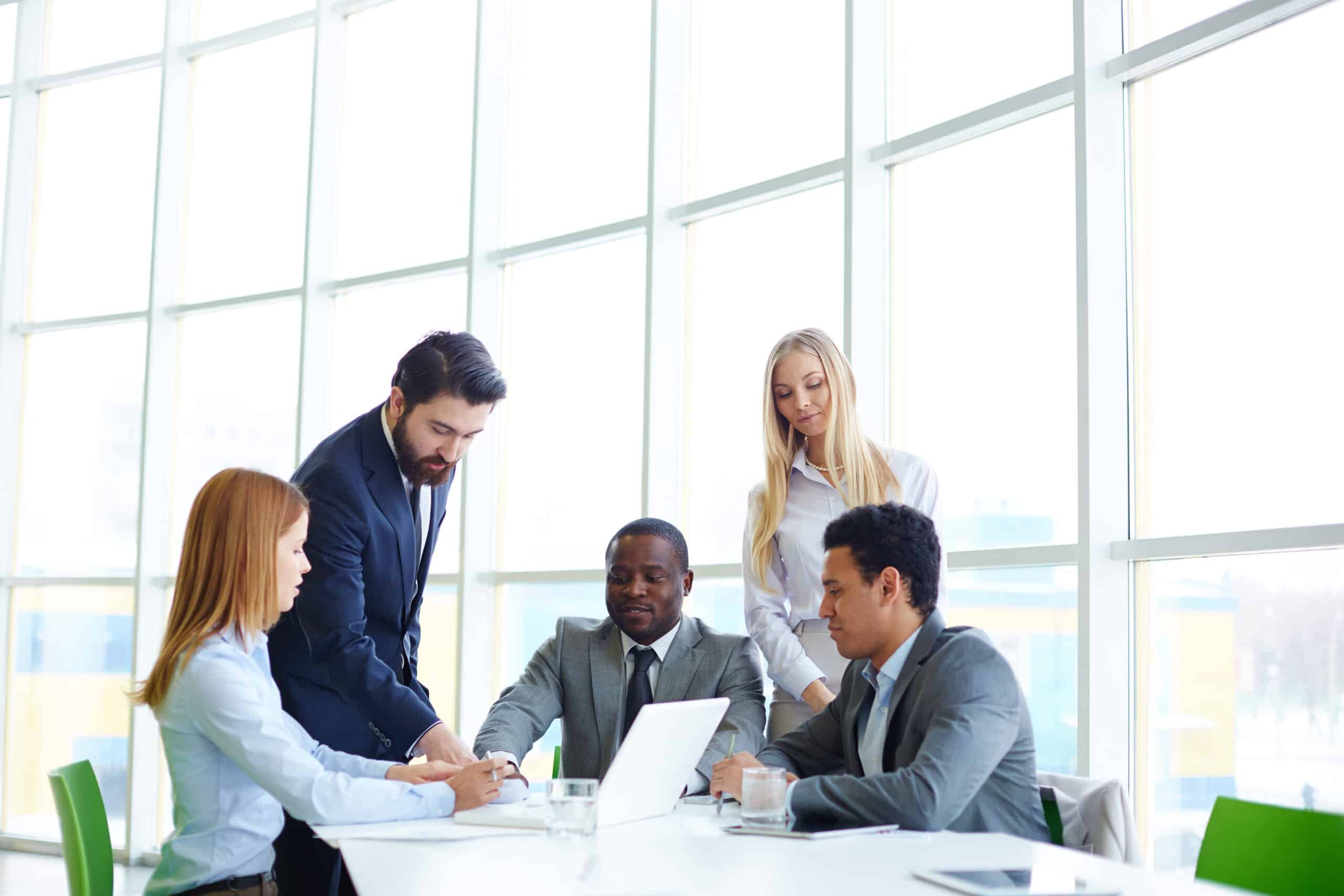 A group of business people collaborating over a laptop.