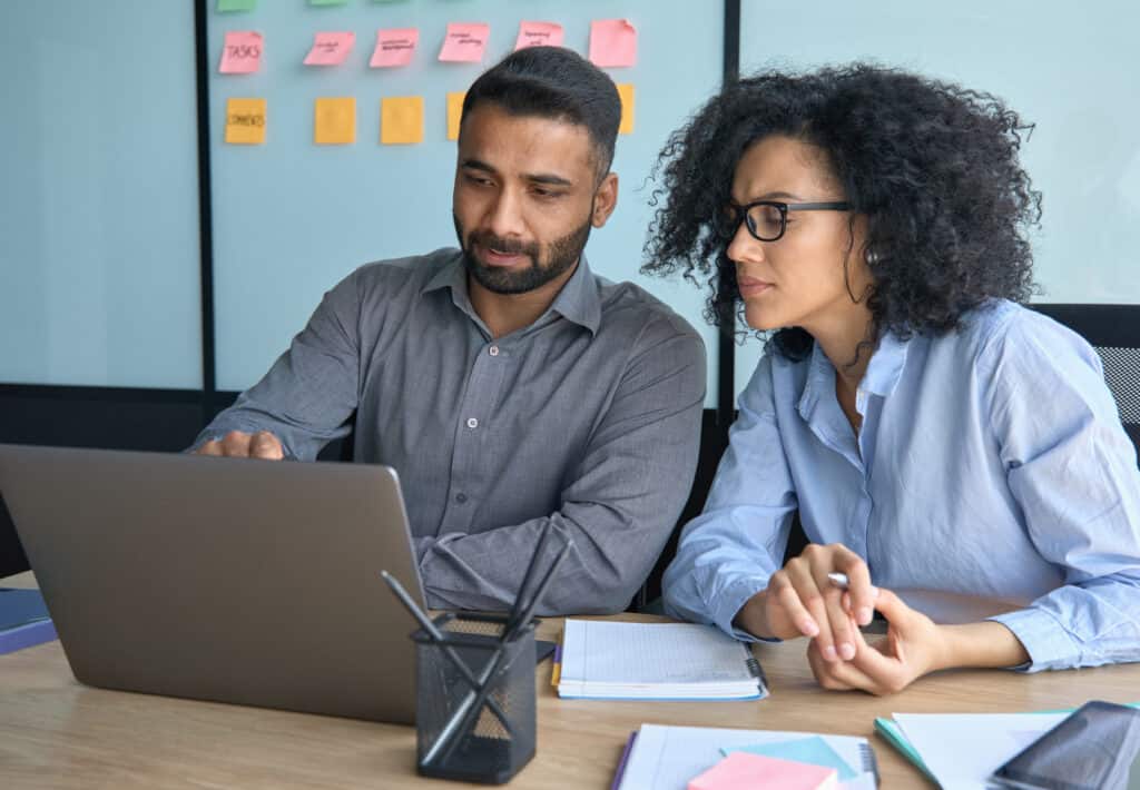 Man and Woman Working on Same Laptop