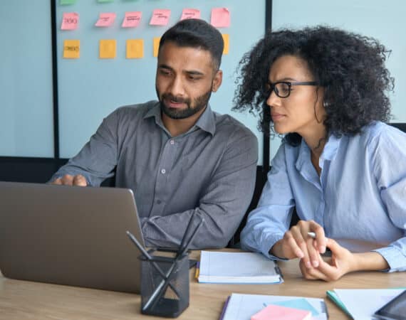 Man and Woman Working on Same Laptop
