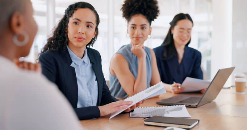 Professional women sitting around conference table